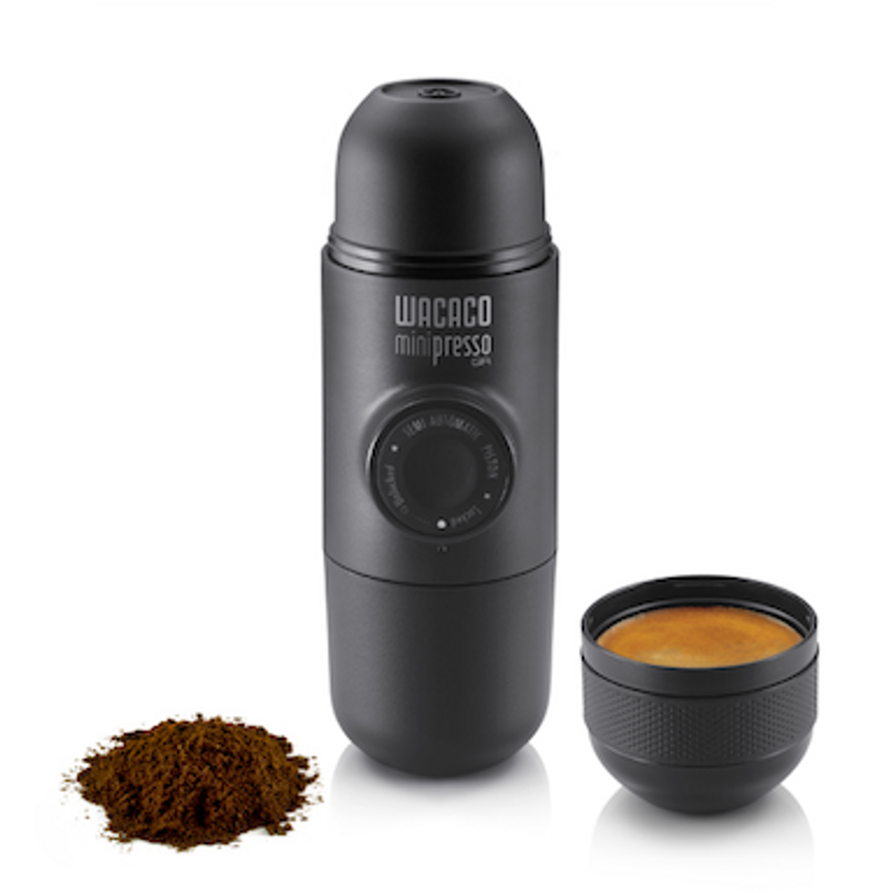 The Wacaco Minipresso GR with coffee grounds shown next to it