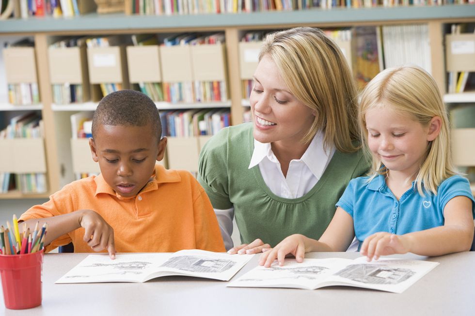 A teacher helps her students read after getting the job