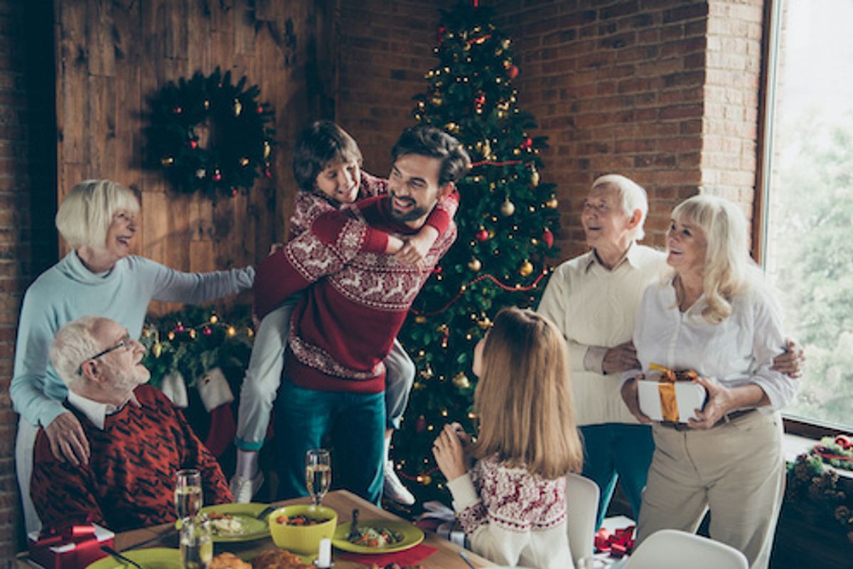 Multi-generational family gathered together in front of holiday decorations