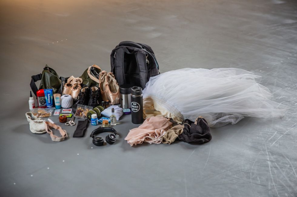 The contents of Lauren Lovette's emptied backpack and duffle back are laid out on the floor of a dance studio.