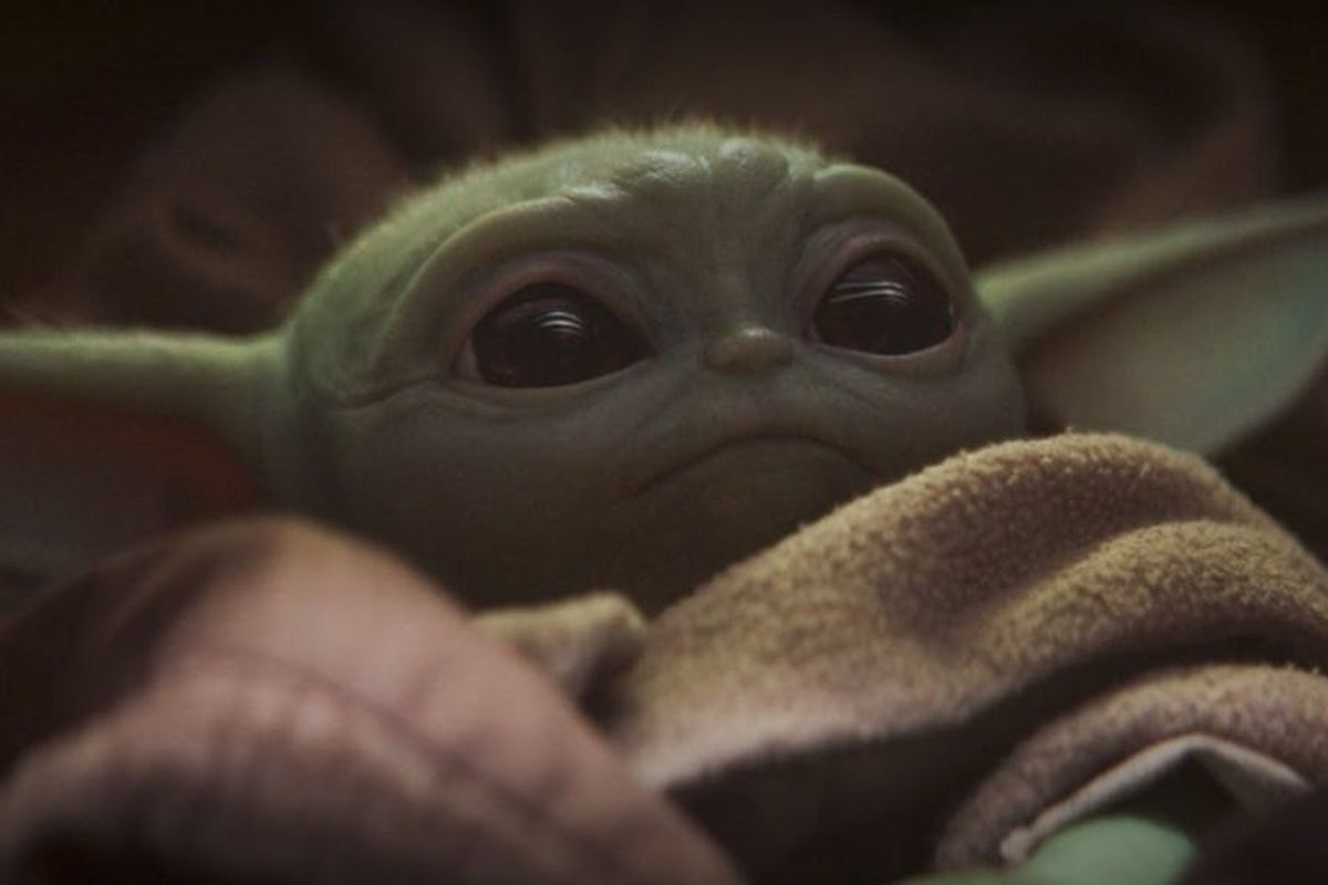 Baby Yoda looking up at the hero of "The Mandalorian"