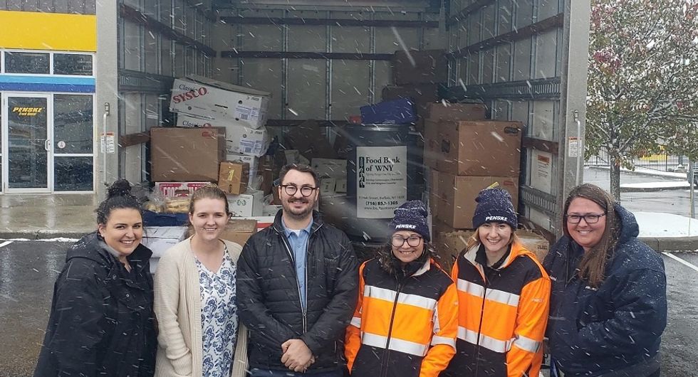 Penske employees in front of truck full of donations