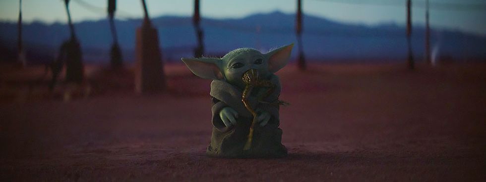 Baby Yoda enjoys eating a frog.