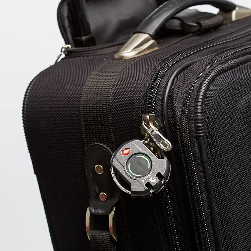 An Airbolt luggage lock on a black zippered bag