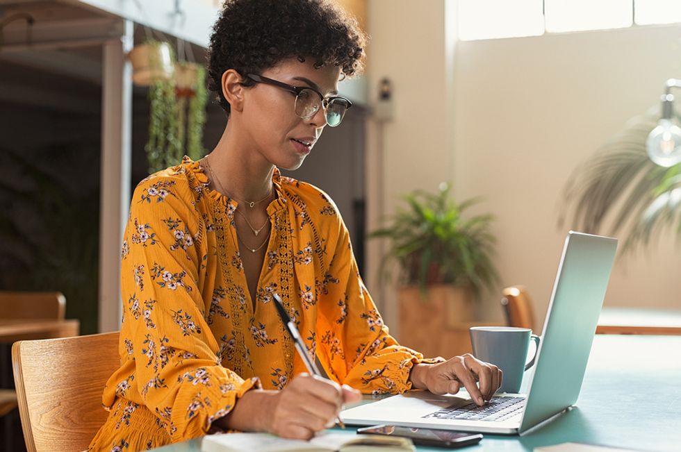 Young professional woman pursuing her hobby of writing after getting laid off at work.