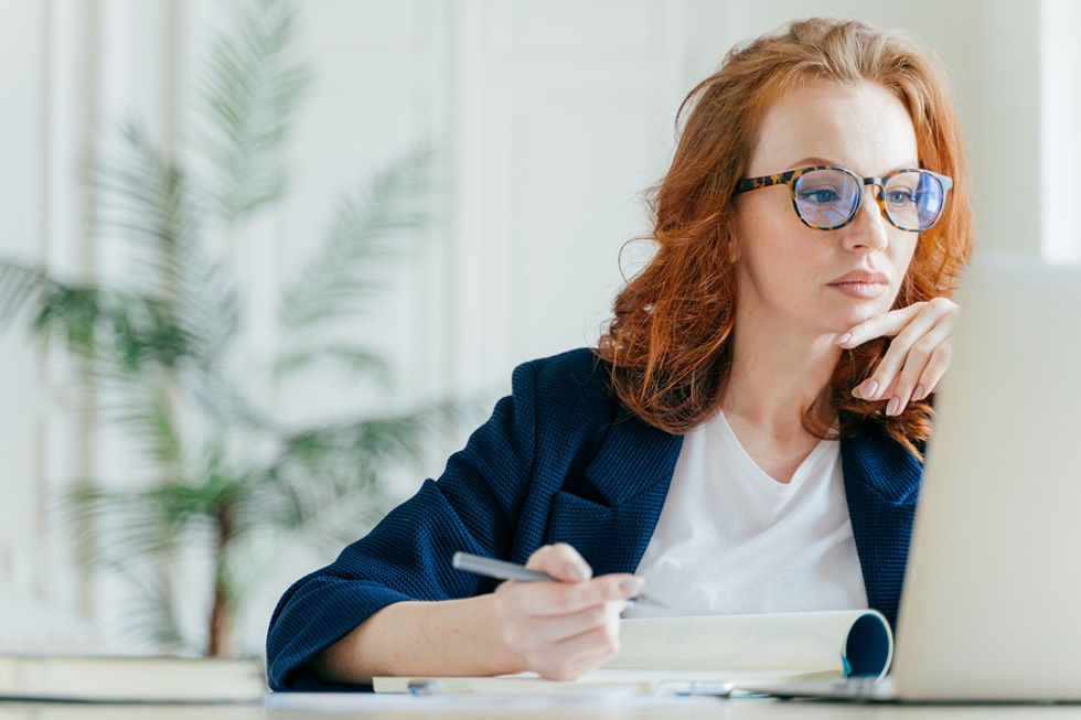 Young professional woman taking an online course after getting laid off from her job.