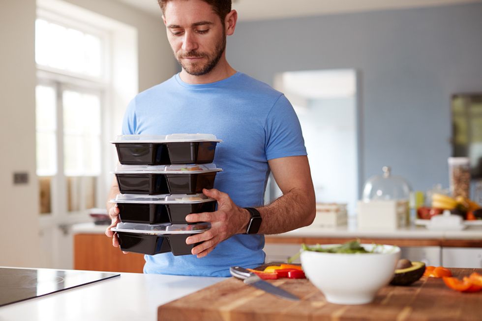 Young professional man preparing healthy meals after being laid off from his job.