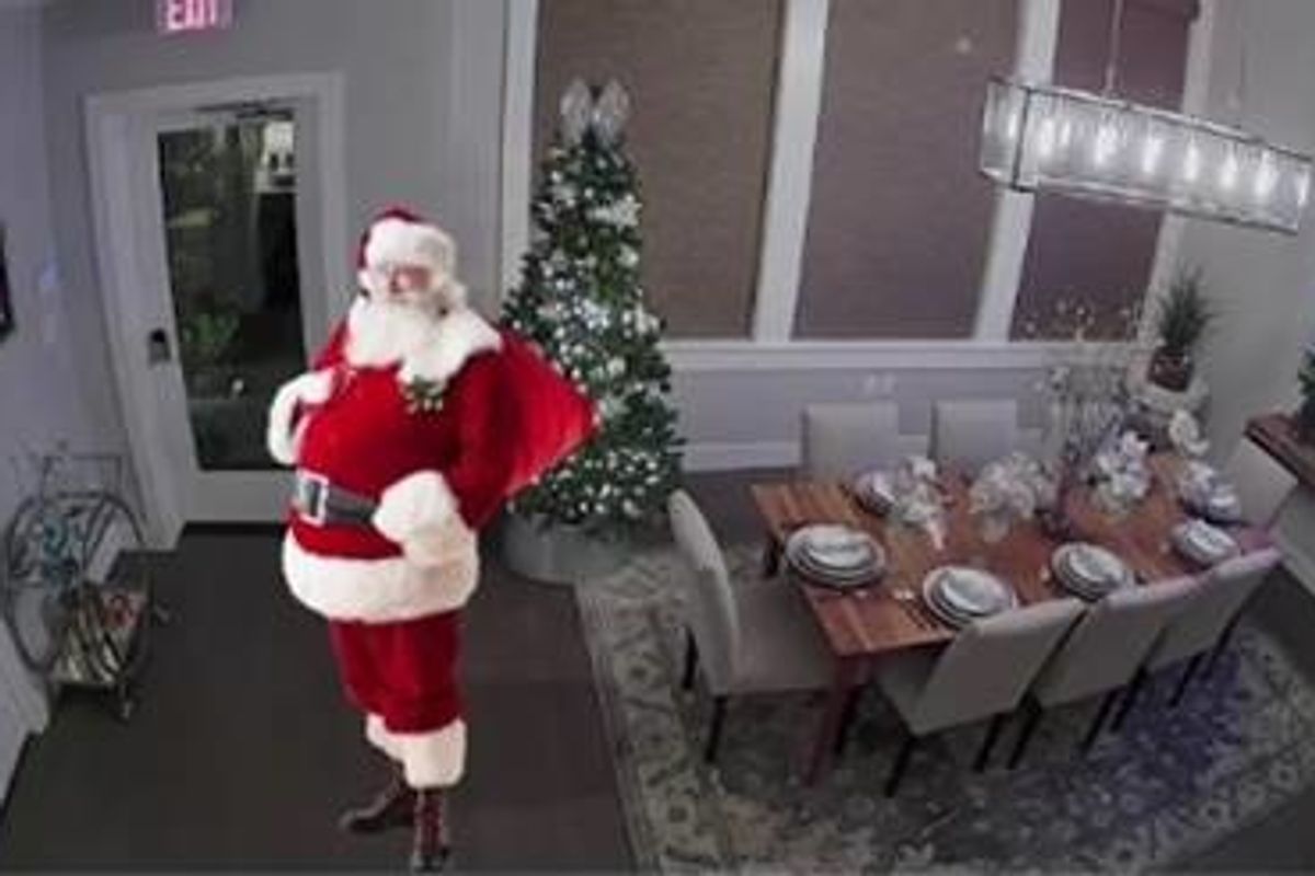 An augmented image of Santa Claus in a living room made to look like security footage