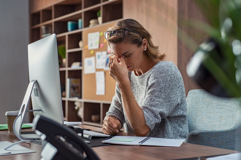 Woman sitting at her desk stressed about her career future in the recession