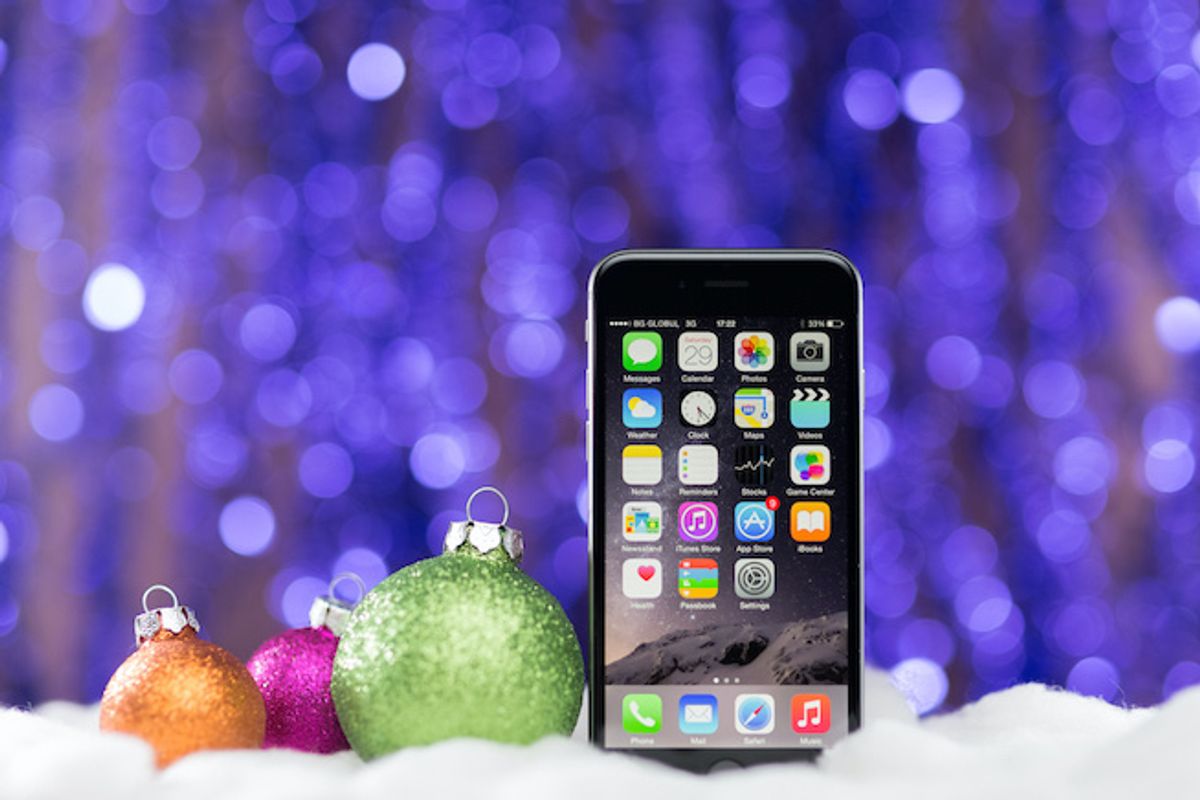 A smartphone seated next to holiday ornaments