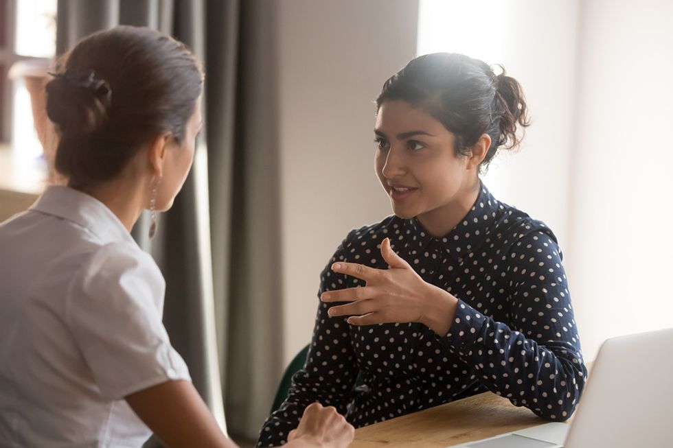Millennial and Gen X co-workers talk during a meeting