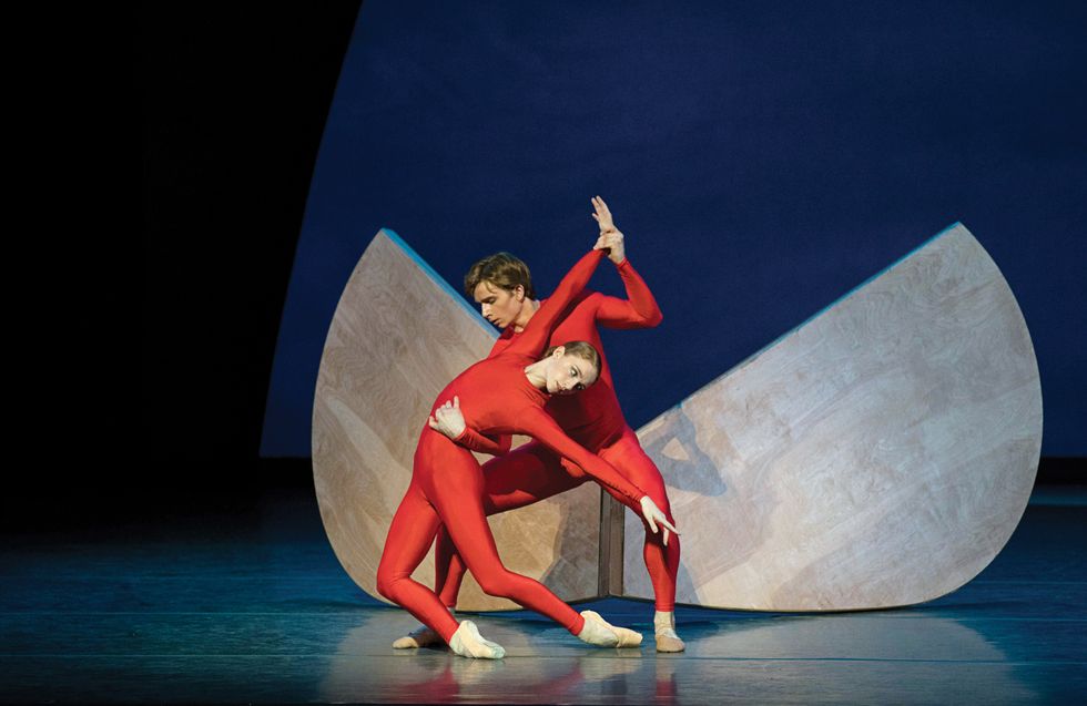 Bell and Hurlin in right unitards against a structural backdrop onstage.