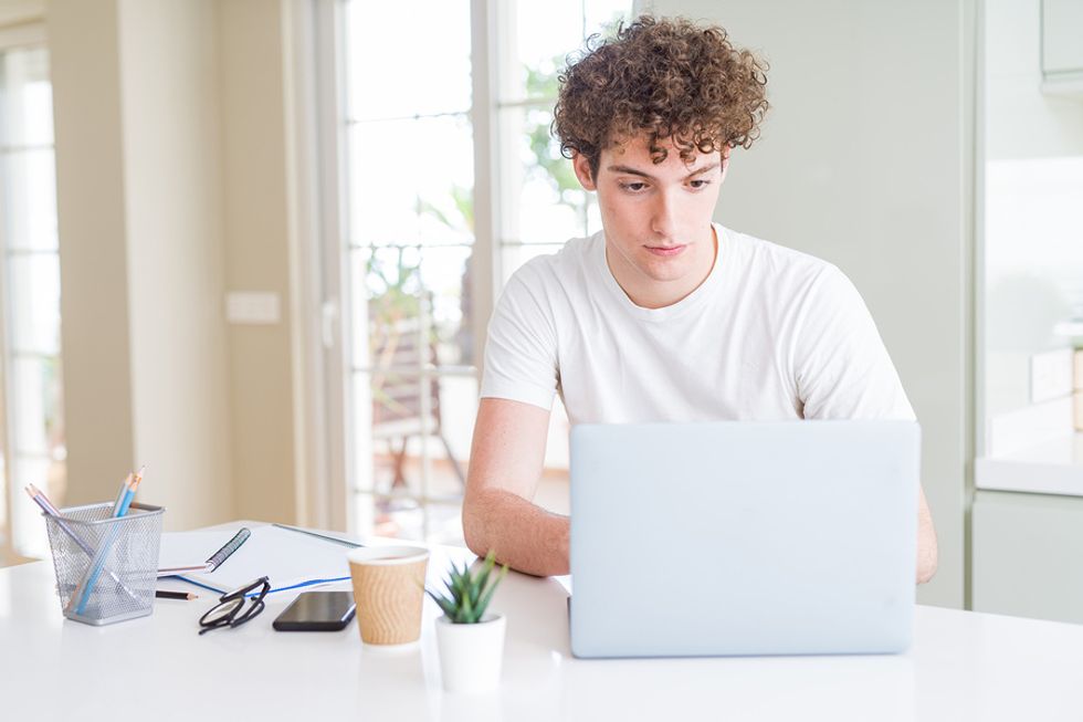 Young man properly optimizing his LinkedIn profile so it gets more views from employers