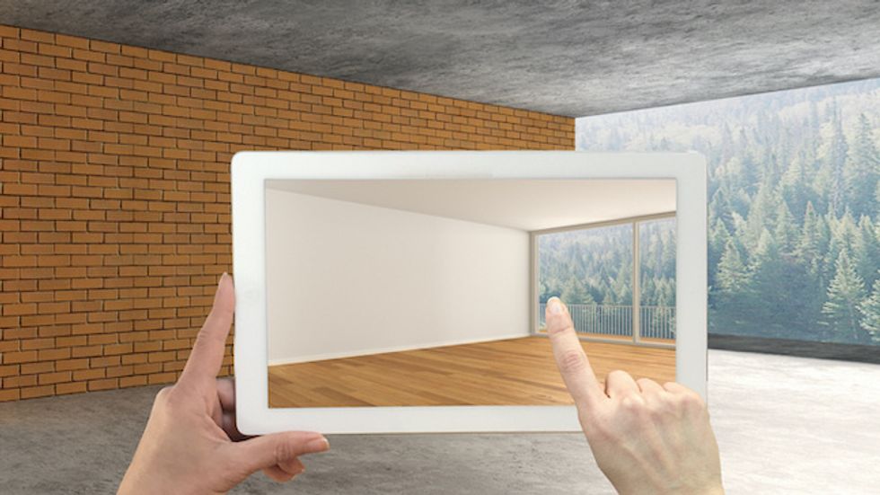 Augmented reality concept. Hand holding tablet with AR application used to simulate furniture and design products in an interior construction site, empty interior with panoramic window