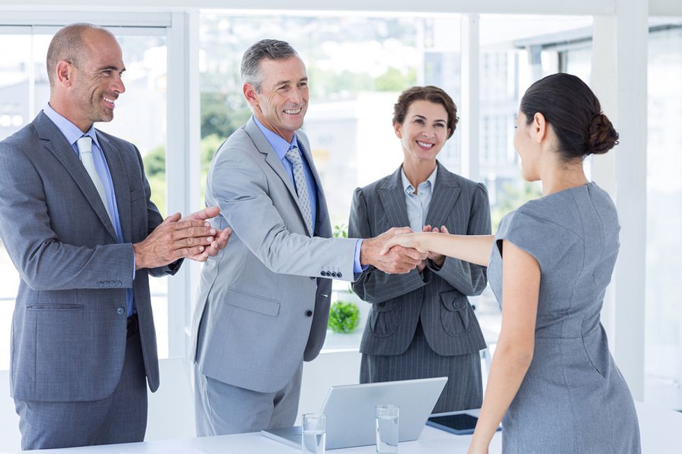 Professional woman thanks the panel of interviewers after her job interview