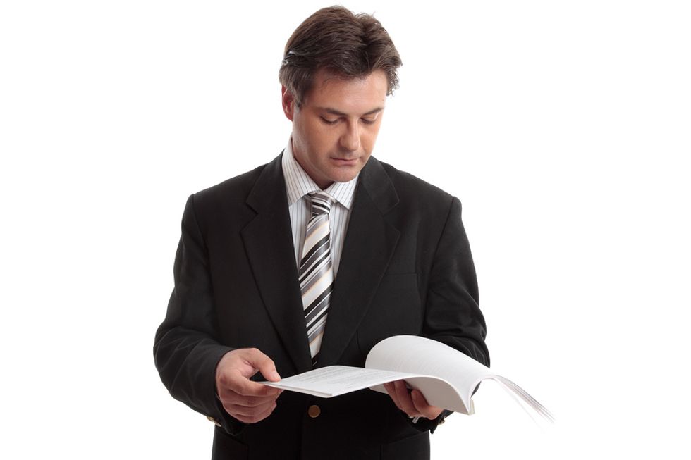 Unemployed businessman gives his updated resume a final review.