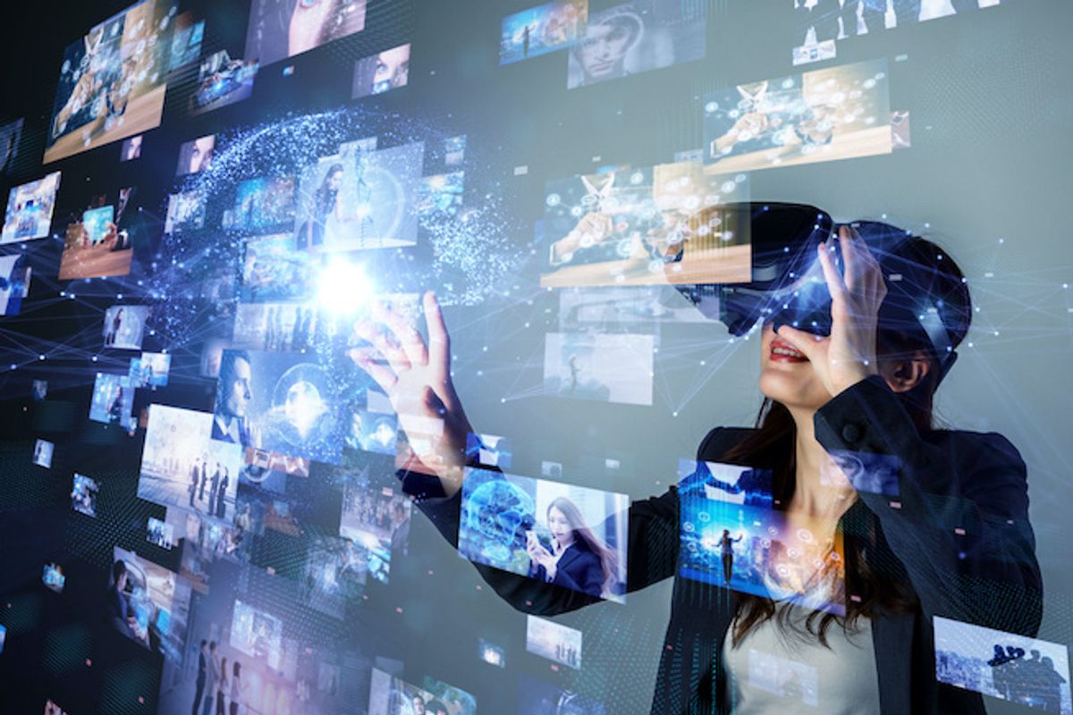 A woman, wearing a virtual headset, in front of a screen with augmented and virtual images in front of her