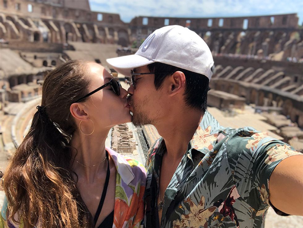 Actor David Lim and wife Marketa Kazdova kissing in front of the Roman Colosseum.