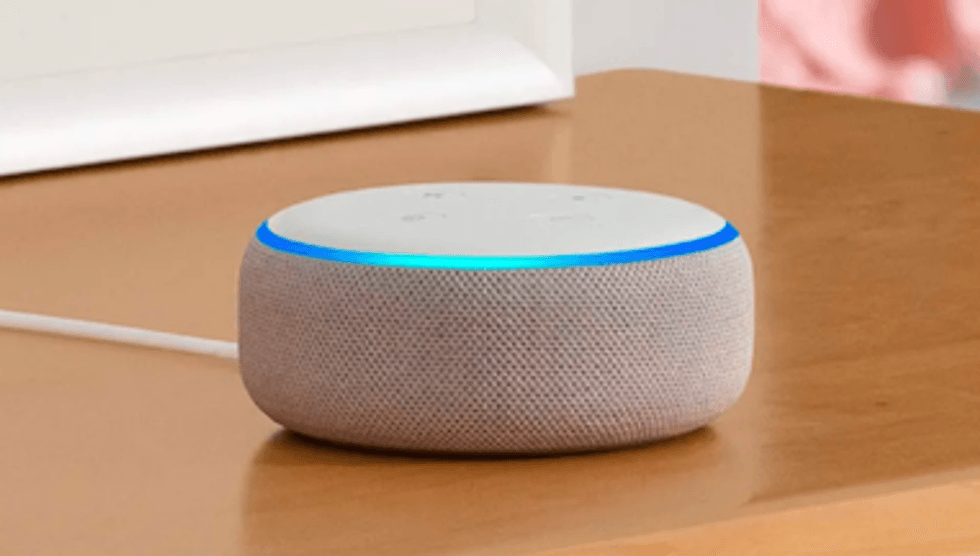 An Amazon Echo Mini smart speaker with the blue light on