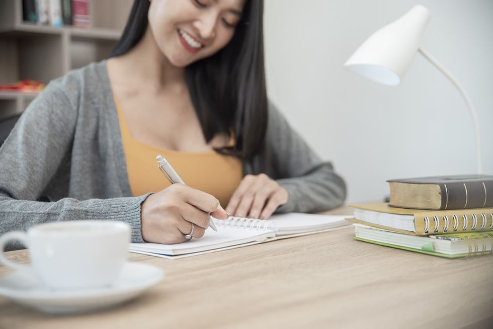 Business woman carefully plans her day with a daily planner.