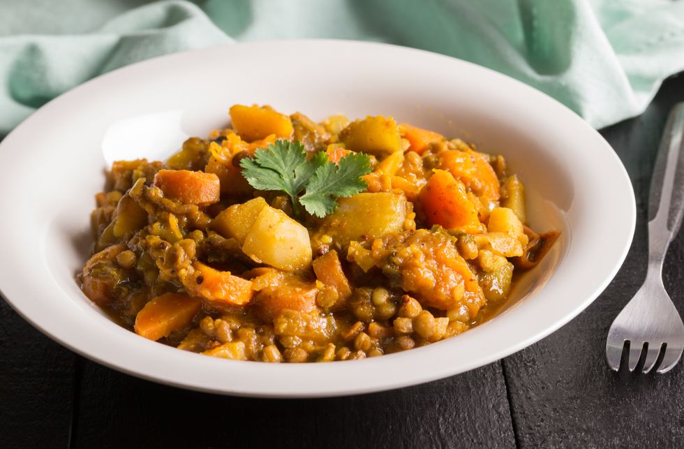 Lentil curry in a plate close up - Vegan recipe consisting of lentils, celery, carrot, potatoes and spices