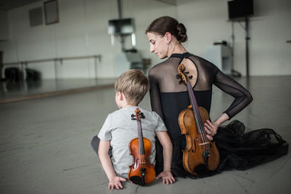 Maria Seletskaya sits in the studio with her son, each of them with a violin behind their backs