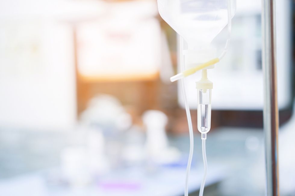An IV bag with drip on a blurred background