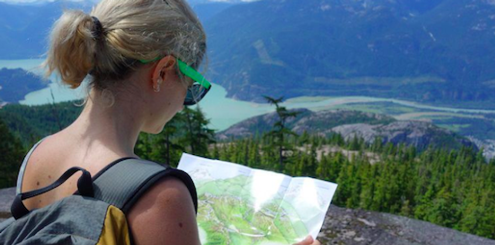 A hiker looking at a map in the wilderness