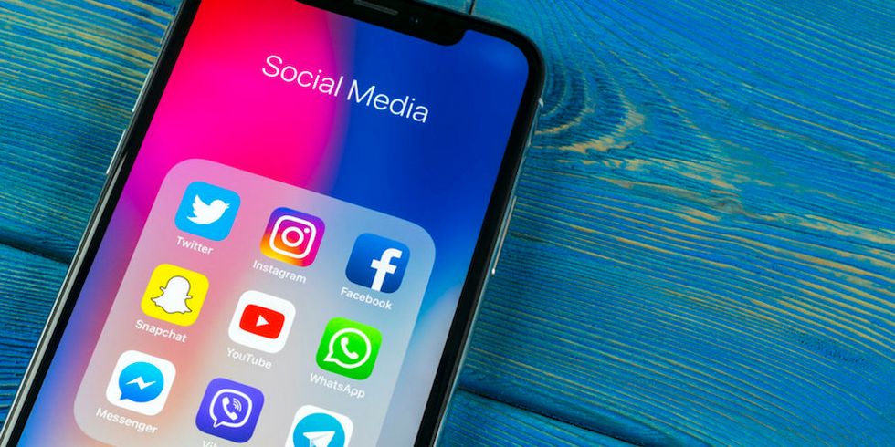 An iPhone displaying apps including Twitter, Snapchat and Facebook