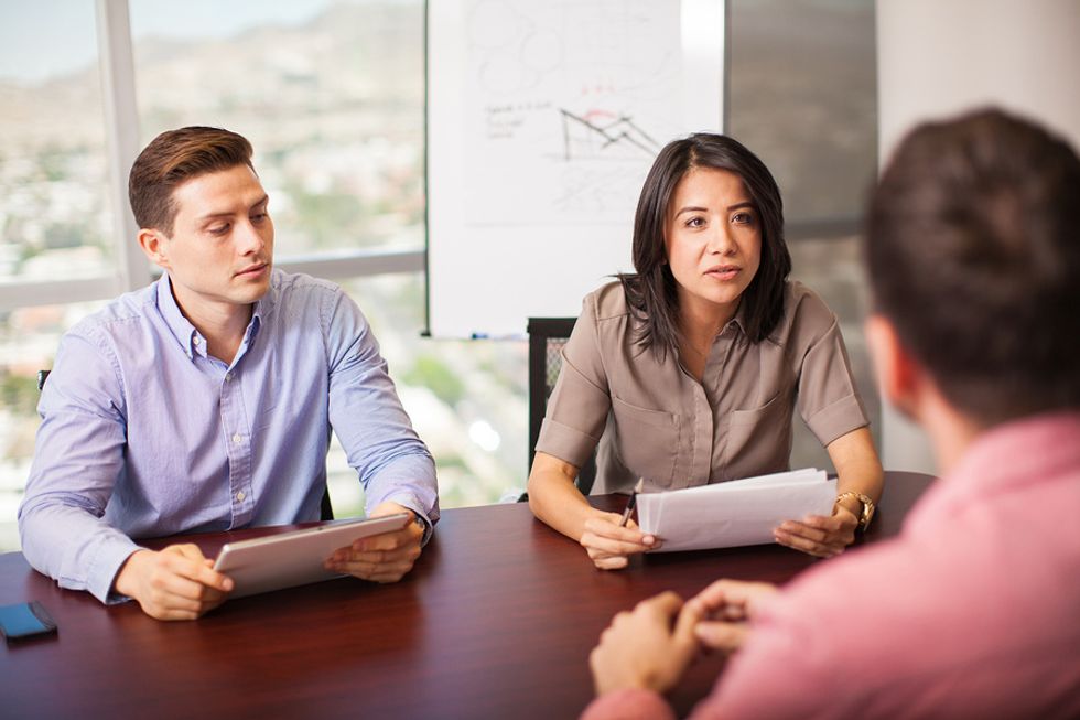 Interviewers ask an engineering job candidate a question