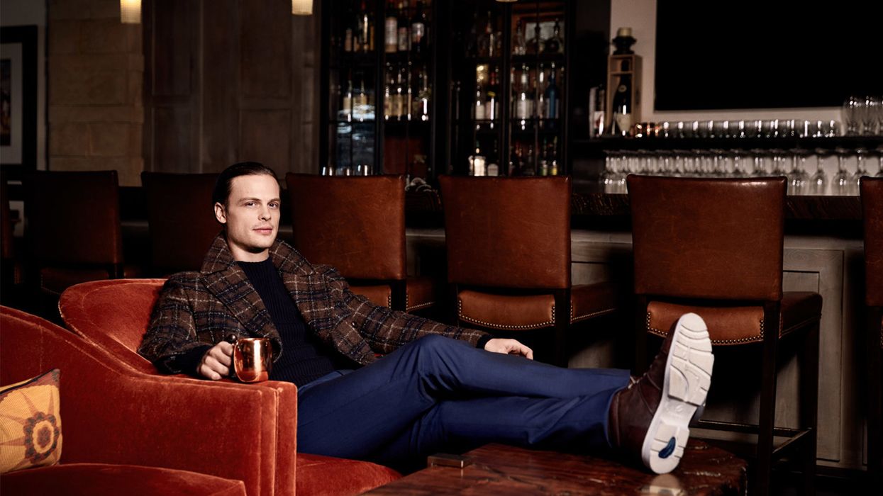 \u200bMatthew Gray Gubler of Criminal Minds lounging in armchair at the a bar.
