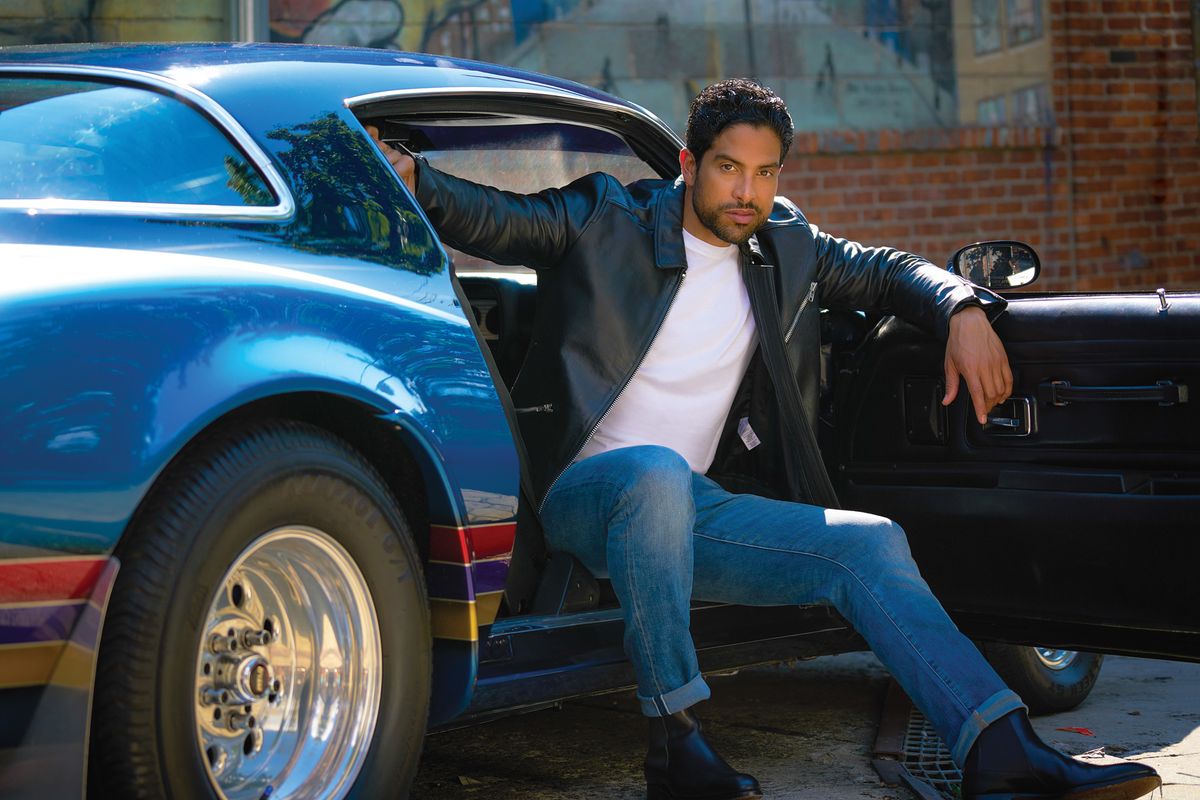 Adam Rodriguez sitting in the passenger seat of a hot rod.