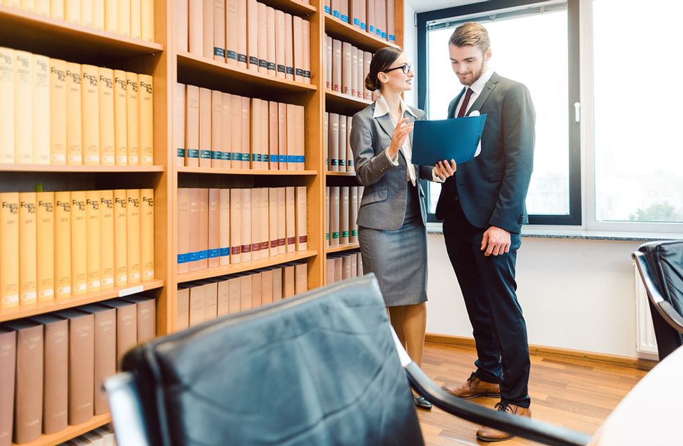 Two lawyers with good teamwork skills working together on a case