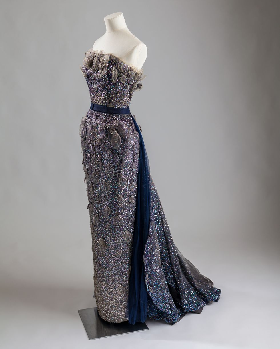 Mannequin wearing a navy jeweled strapless evening gown.