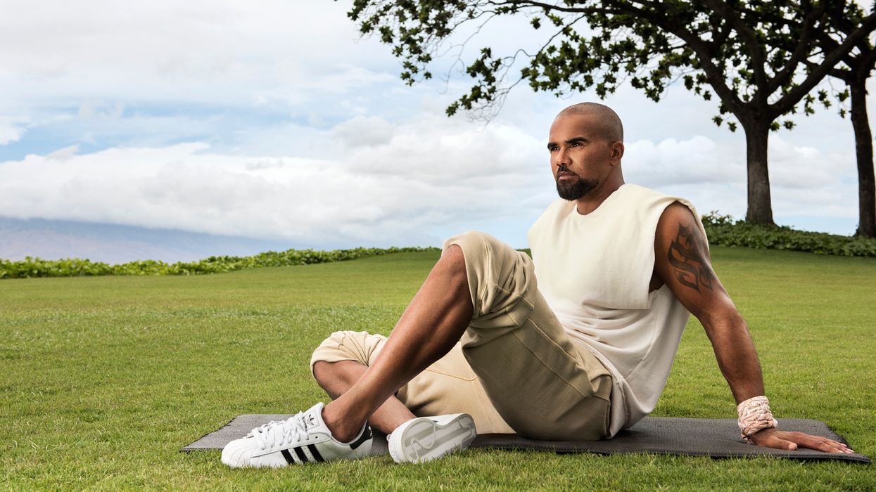 Shemar Moores sitting on a yoga mat.