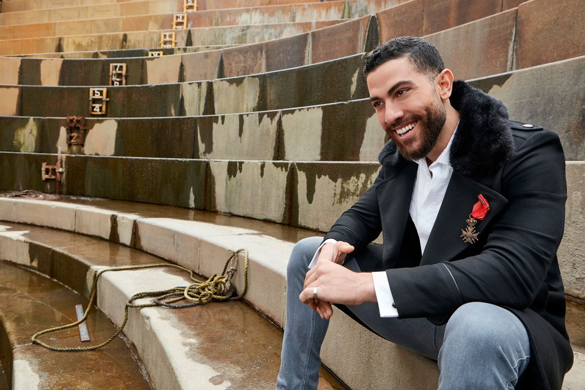 Zeeko Zaki smiling and sitting on steps.