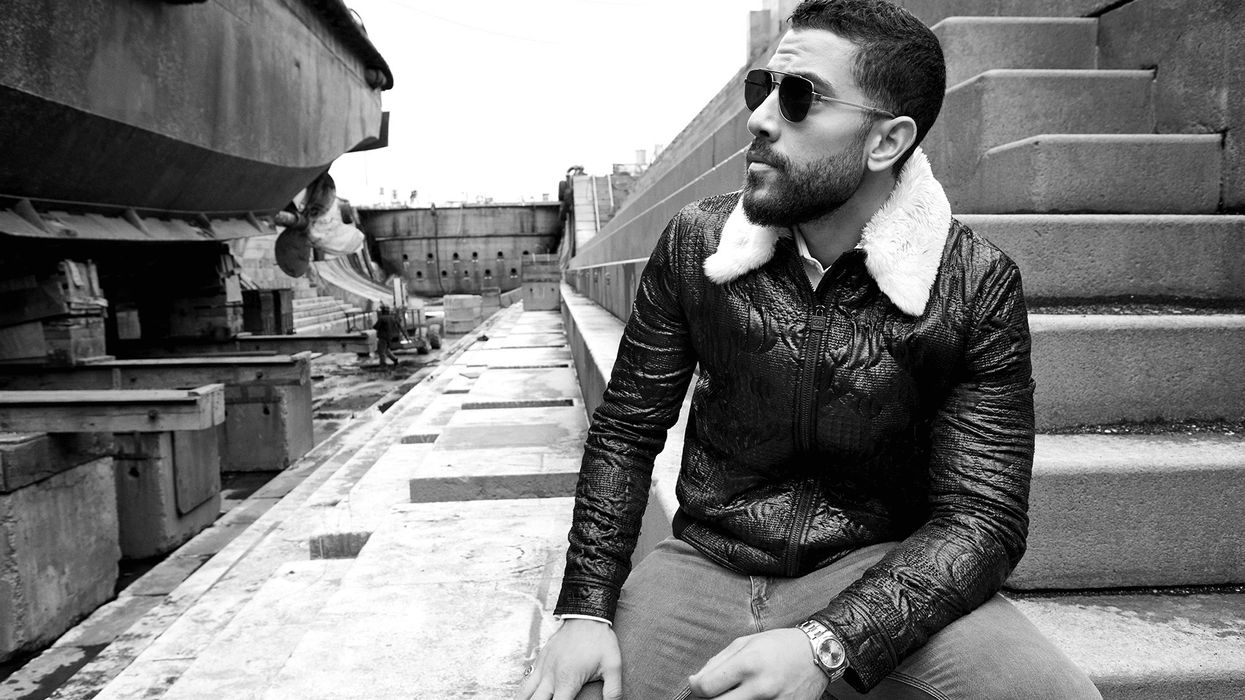 Black and white photo of Zeeko Zaki wearing sunglasses and a winter jacket.