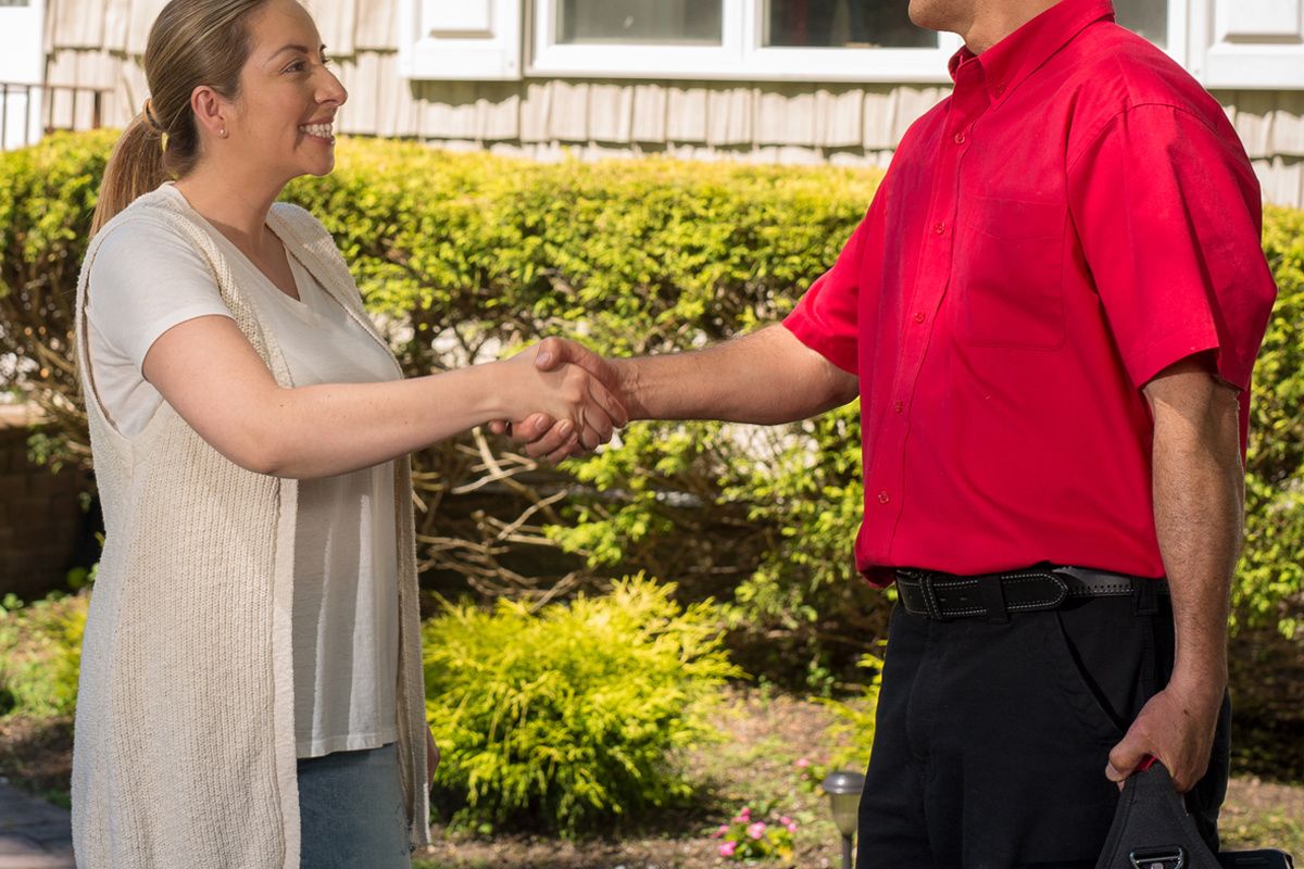 woman shaking a service mans hand outside her house