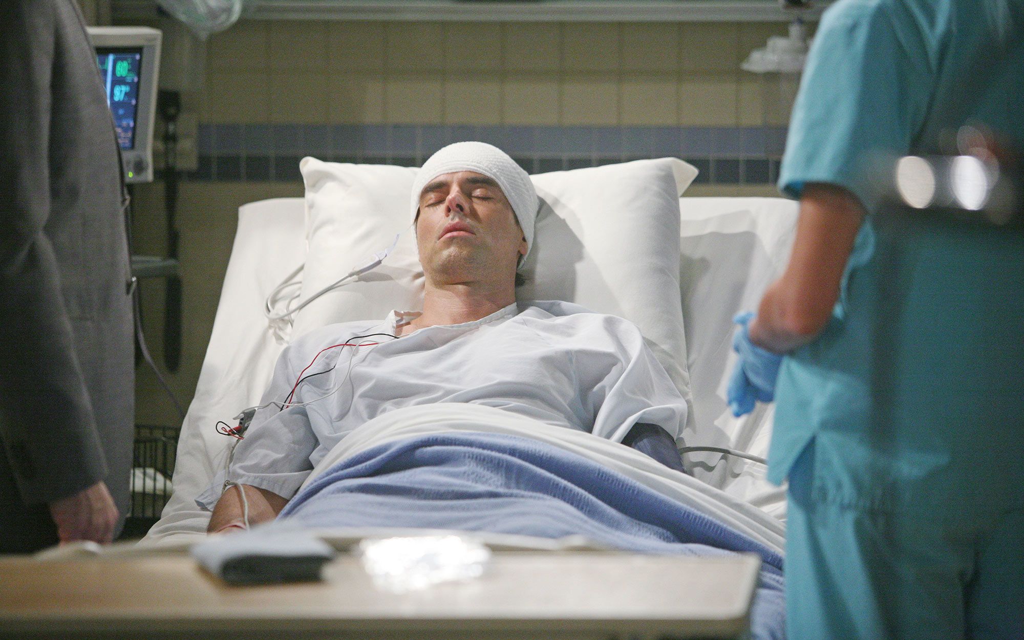 Jason Thompson laying in a hospital bed for a scene in The Young and the Restless.