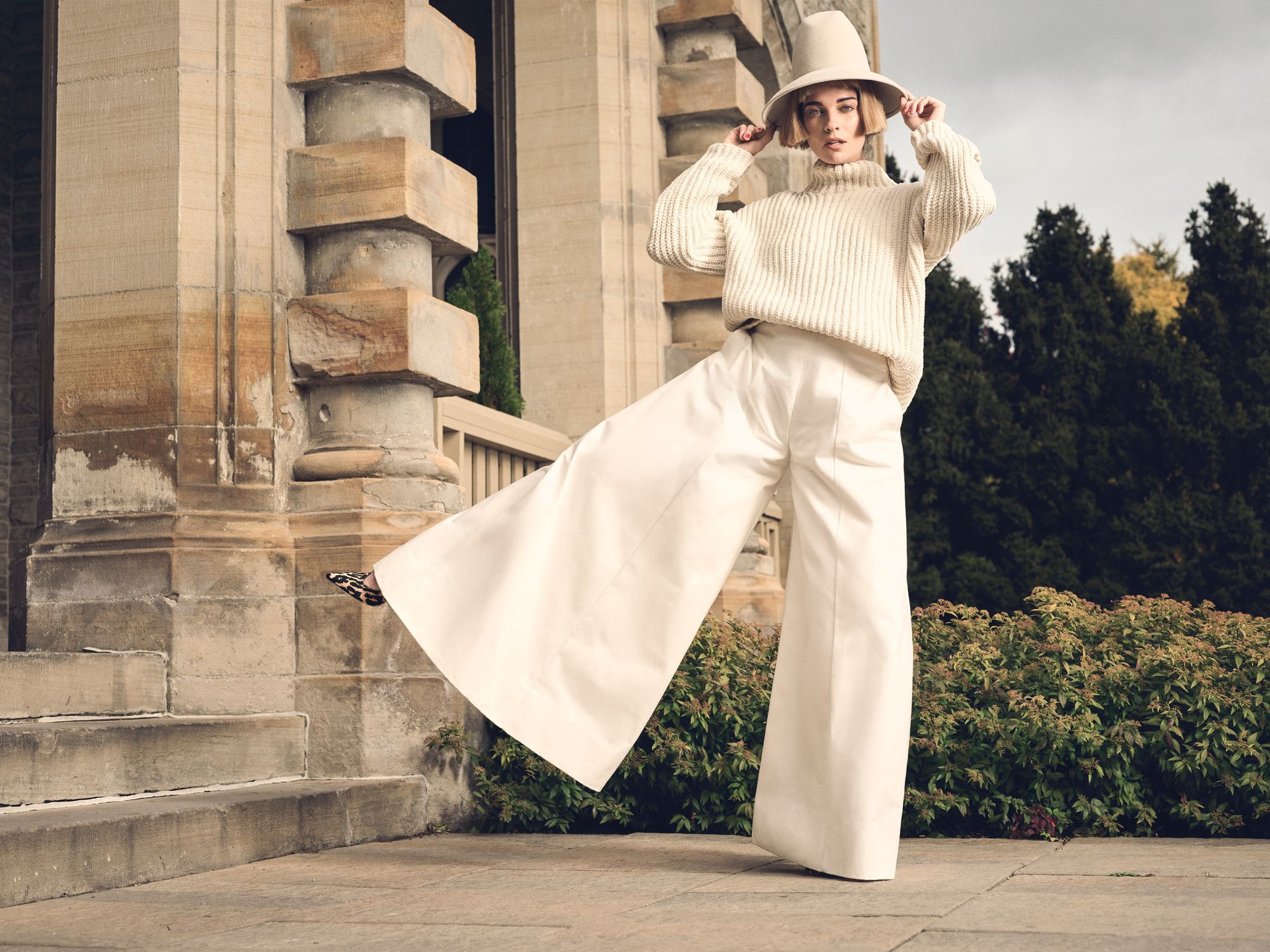 Annie Murphy wearing all white and extra-wide pants.