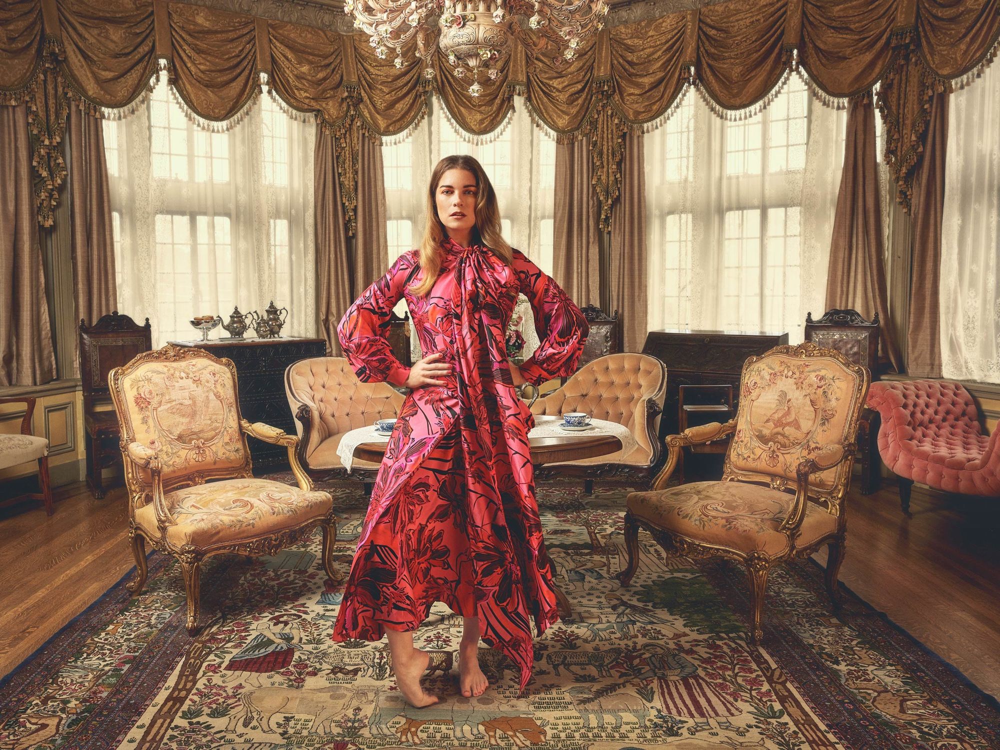 Annie Murphy standing in an elegant sitting room.