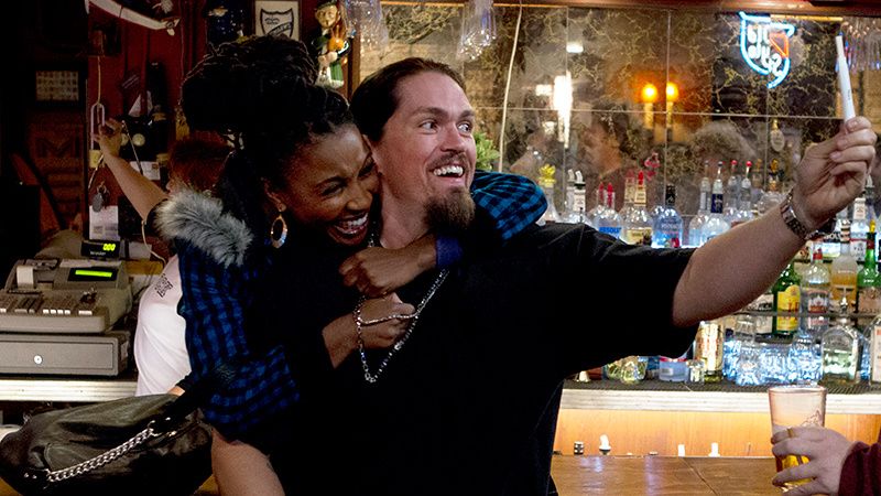 Actors Shanola Hampton and Steve Howey in a bar.