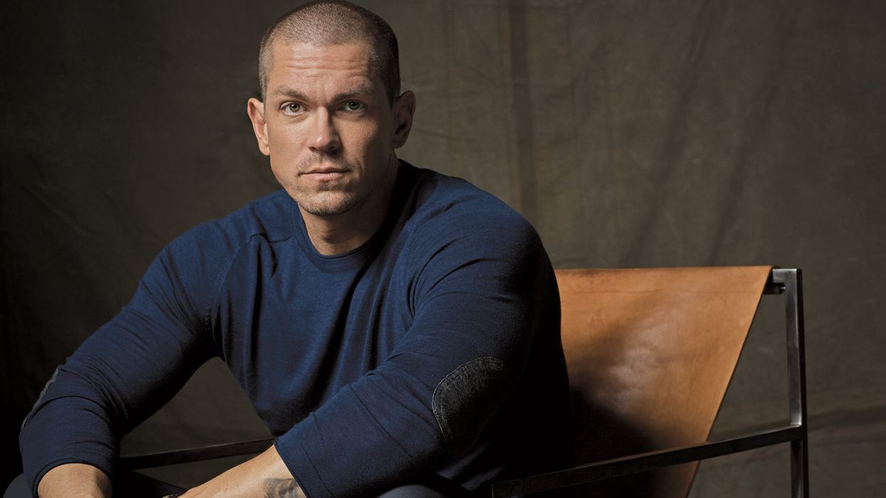 Actor Steve Howey sitting in a chair.