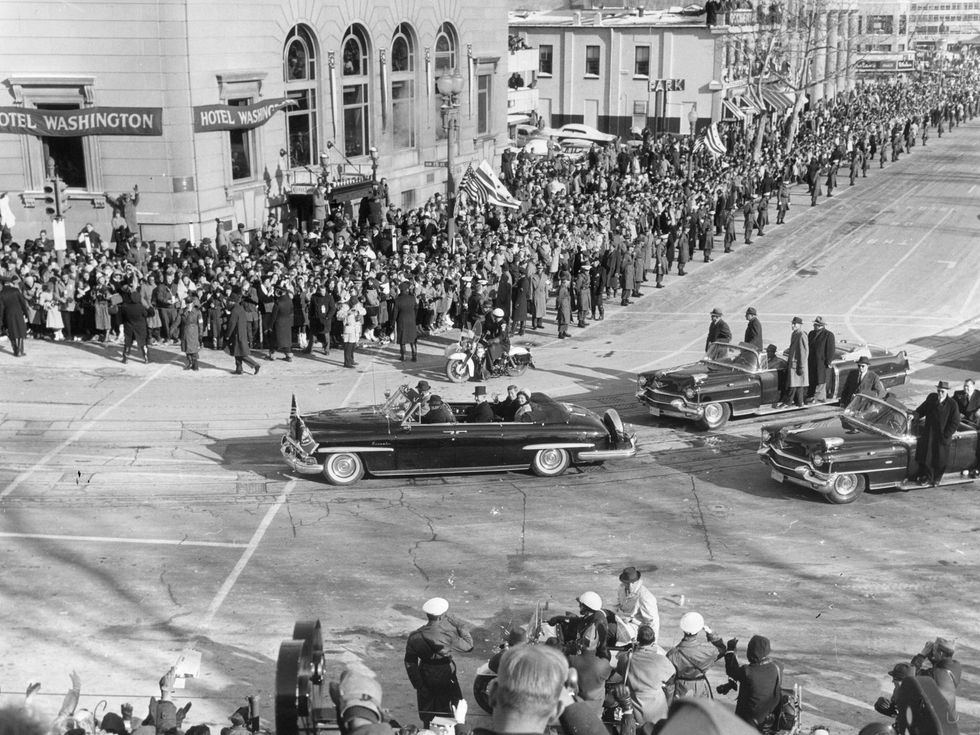 President John F Kennedy is driven through the crowded streets with his wife Jackie on the day of his inauguration. (