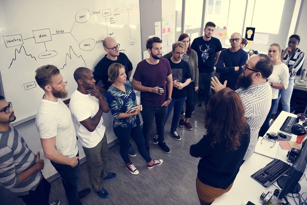 Employees gather to discuss goals at a company meeting.