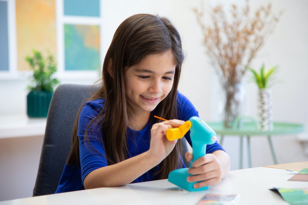 A child playing with the new 3D Build & Play 3Doodler pen