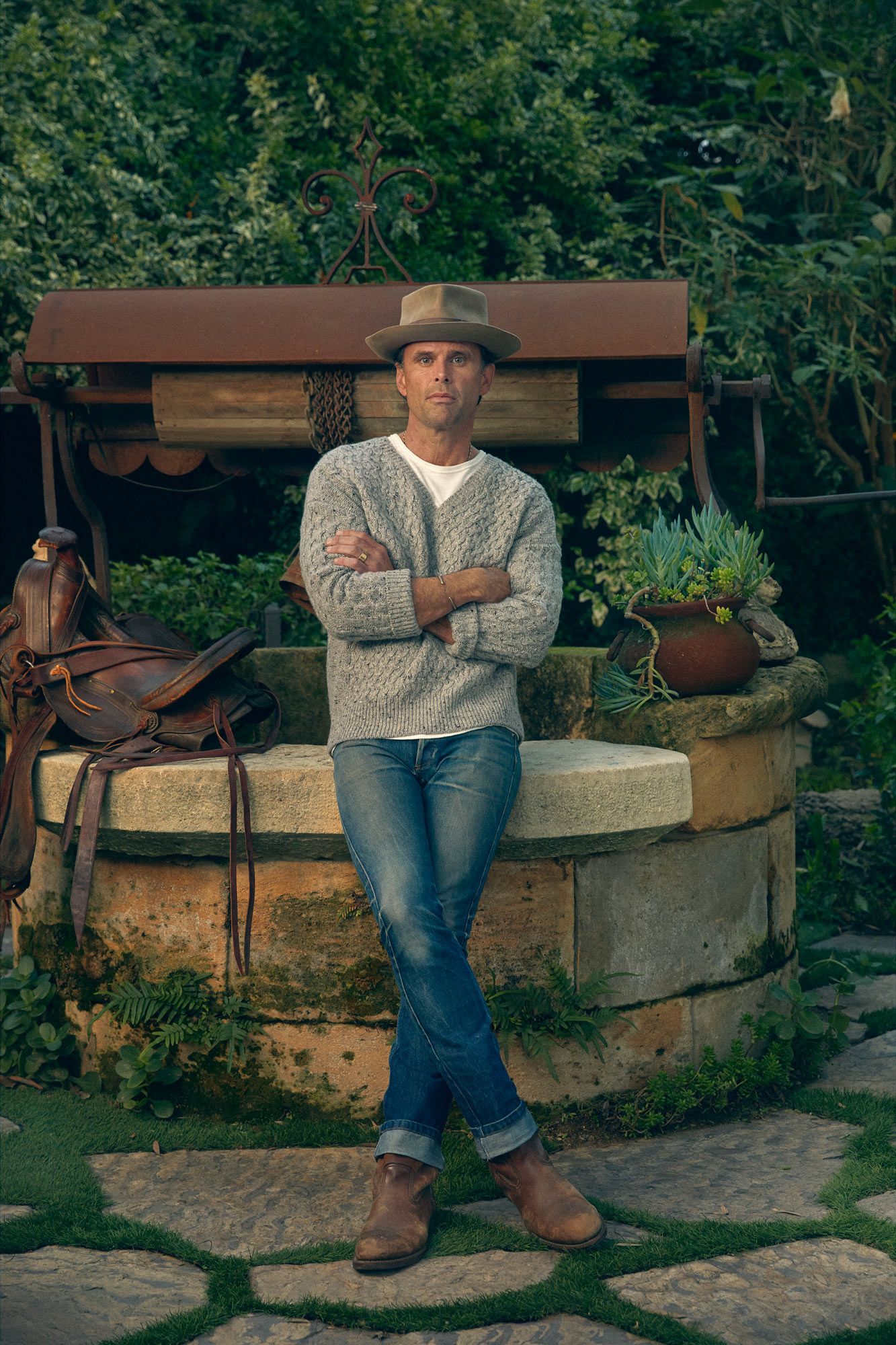 Walton Goggins leaning against a well.