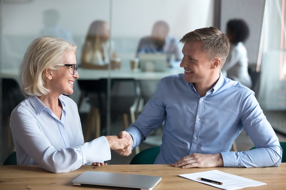 Professional man receives advice about career success from an older co-worker