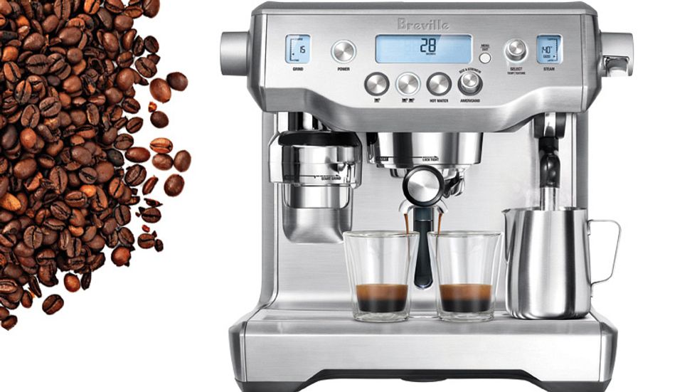 A silver espresso machine in mid brew.
