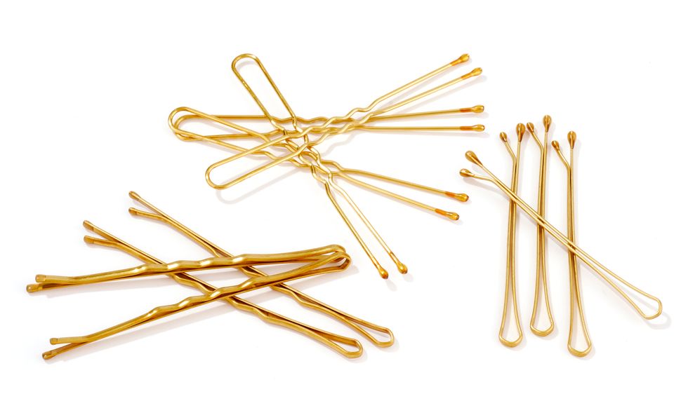 Gold bobby pins against a white background.